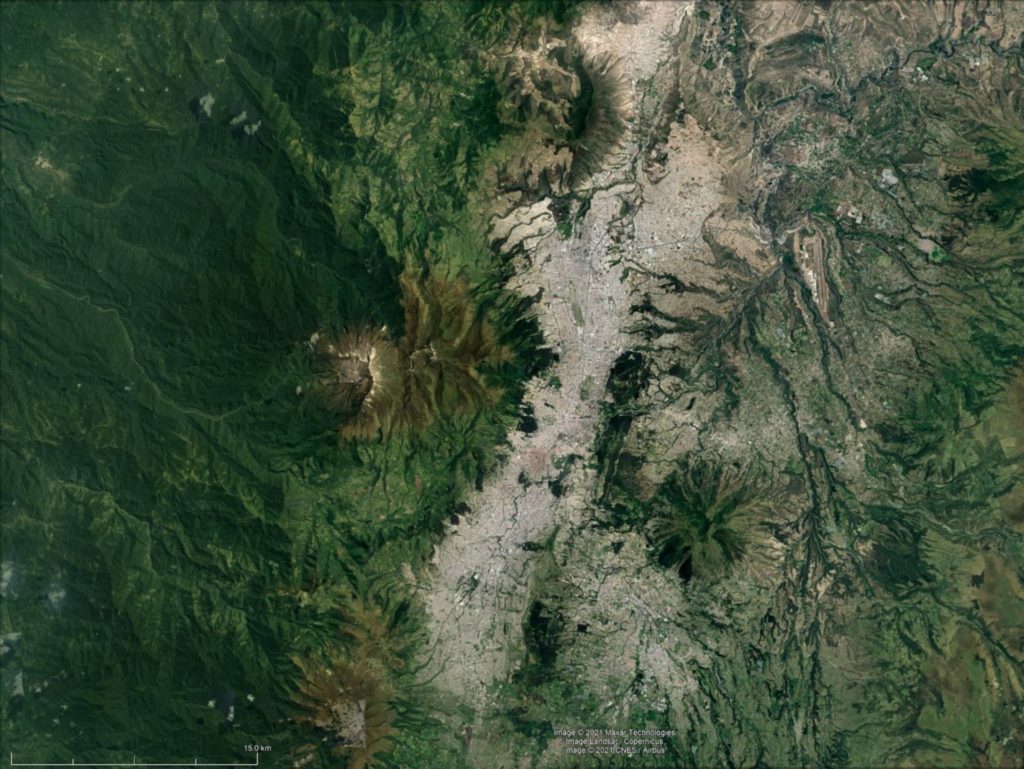 Satellite Image Composite over Quito city, Ecuador and surrounding landscape illustrating greyness of city urban extent versus greeness of the mountains and surrounding area.
